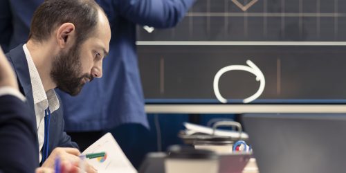 Corporate employees examining organizational progress during a meeting, conducting an analysis or benchmarking exercises. Business specialists discuss activities for expansion plans.